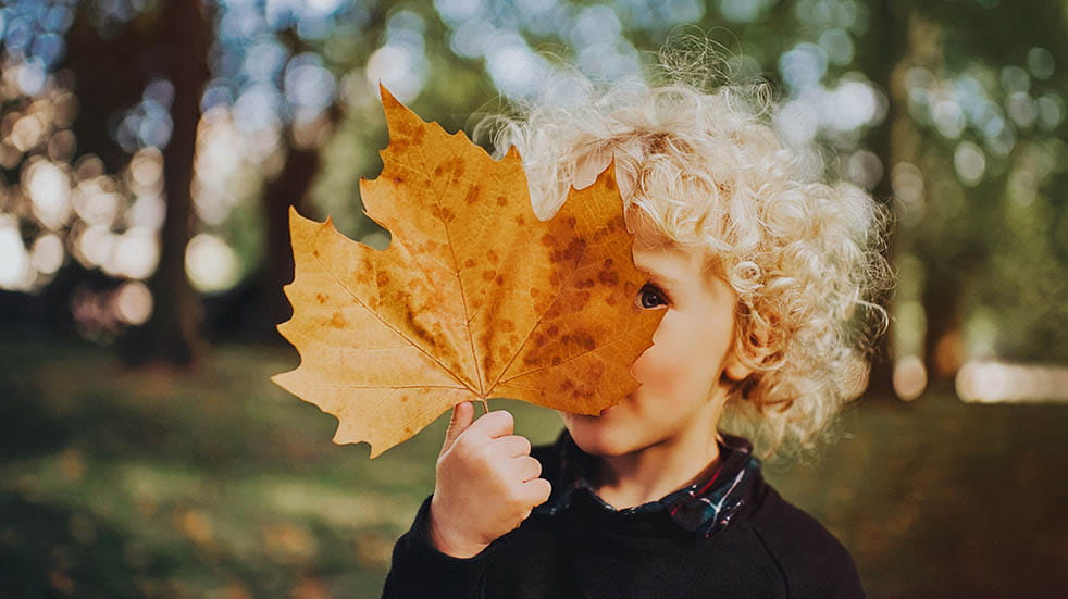 10 easy ways to boost your mood this autumn child looking from behind leaf